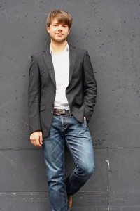 Chorleiter Simon Fröhlich, lässig gegen eine Wand gelehnt