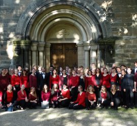 Gruppenfoto des Chores in Konzertkleidung vor einem Kirchenportal
